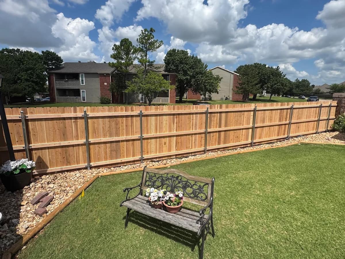 Cedar wood privacy fence professionally installed in an Oklahoma City backyard under a clear blue sky