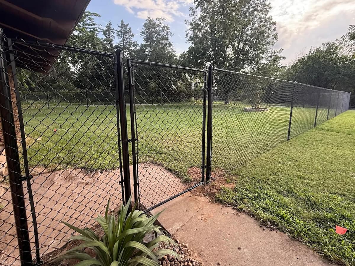 Black chain-link fence around an Oklahoma backyard