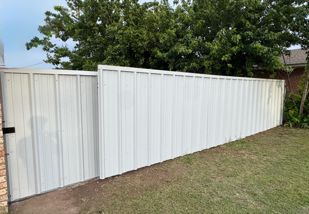 White panel privacy fence with a clean modern finish installed along a residential lawn